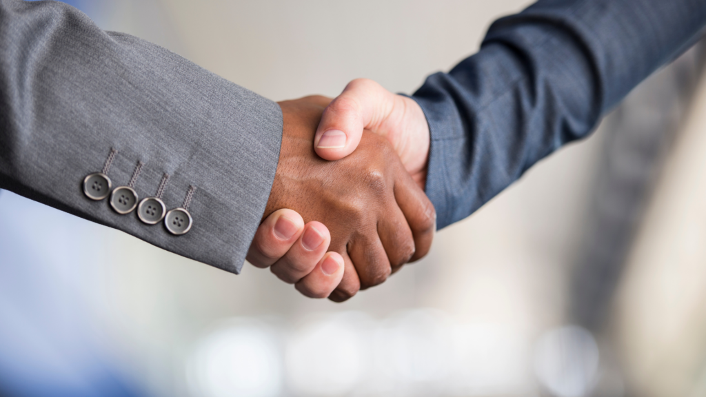 Duas pessoas apertando as mãos, simbolizando uma negociação entre cliente e fornecedores